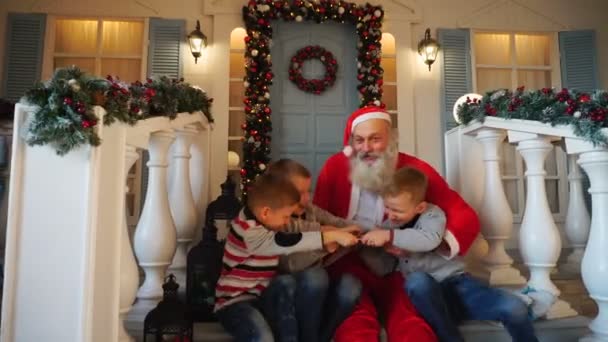 Mischievous boys taking away present from Santa Claus. — Stock Video