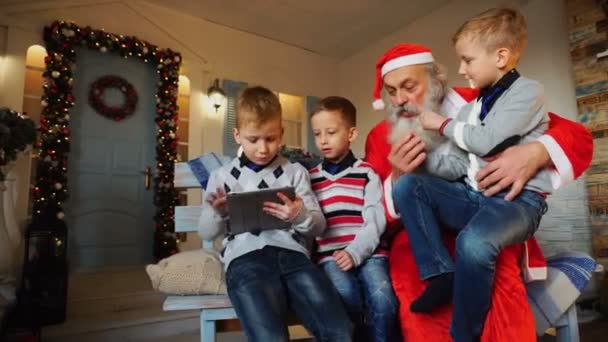 Маленькие мальчики с Санта-Клаусом играют с планшетом . — стоковое видео
