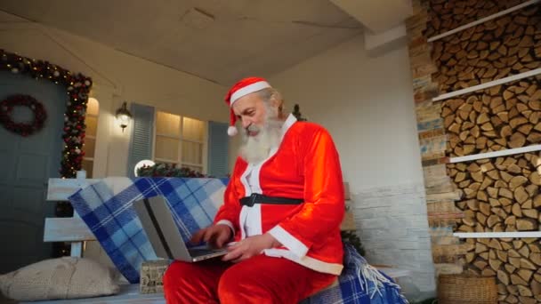 Милостивий Санта-Клауса, працюючи на ноутбук. — стокове відео