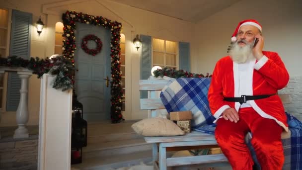 Lustiger Weihnachtsmann telefoniert mit Eltern. — Stockvideo