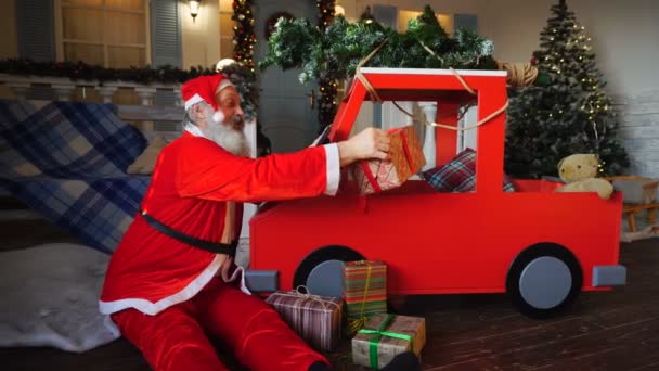 Смешной Санта-Клаус чтение детских желаний на планшете и проверка подарков . — стоковое видео