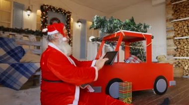 Noel Baba Oda kat ortasına oturur ve çocuklar için hediyeler yapmak tamamlar