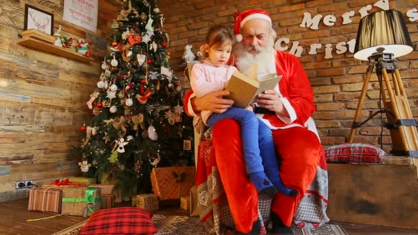 Kleines europäisches Mädchen auf Knien beim Weihnachtsmann. — Stockvideo
