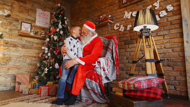 Liten pojke går till Santa och sätter önskan på Santa s öra. — Stockvideo