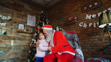 Güçlü kucaklama kız mutlu kadın çocuk ve Noel Baba odasında arasındaki Noel için dekore edilmiş