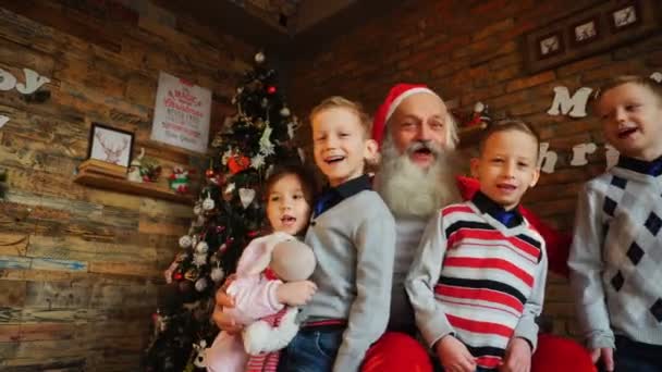 Amigos de meninos e menina emocionalmente gritam canções de Natal com Papai Noel na árvore decorada quarto — Vídeo de Stock