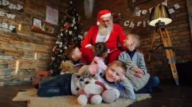 Küçük çocuklar güzel dekore edilmiş oda dekore edilmiş Noel ağacı Noel Baba'ya üzerinden büyüleyici hikaye dinle