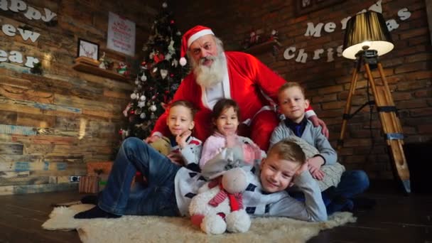 Funny guys waving their palms and raising hands up with Santa Claus in room decorated holiday — Stock Video