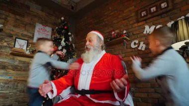 Üç ateşli erkek kardeş Noel Baba odasında üzerinde atlama eğlence ile süslenen Noel süslemeleri ağacı