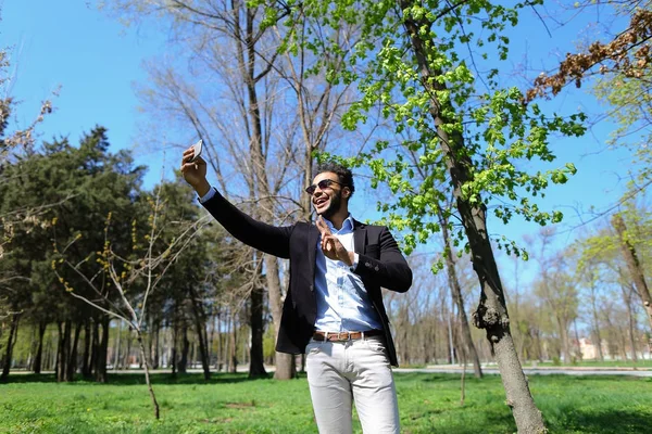Menino muçulmano testando novo telefone e mostrando mão sinal de paz em câmera lenta — Fotografia de Stock