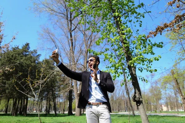 Menino muçulmano testando novo telefone e mostrando mão sinal de paz em câmera lenta — Fotografia de Stock