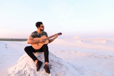 Çekici Arap adam gitar, Hill'de oturan şarkı söylüyor