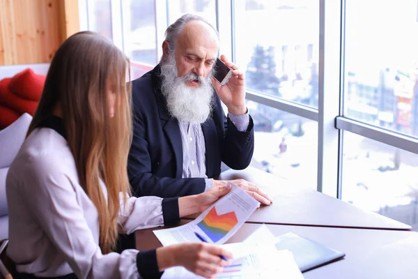 Ervaren ondernemers schakelde neemt oproep op telefoon en aandelen een — Stockfoto