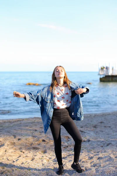 Jovem feliz gosta de clima ensolarado e posando na costa do bl — Fotografia de Stock