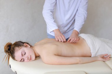 Yakışıklı erkek ortopedi uzmanı geri masaj kadına üzerinde yatan