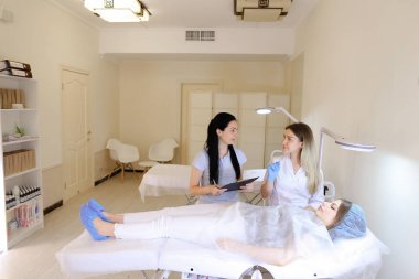 Microblading ustası kadın kız öğrenci kullanmayı öğretir.