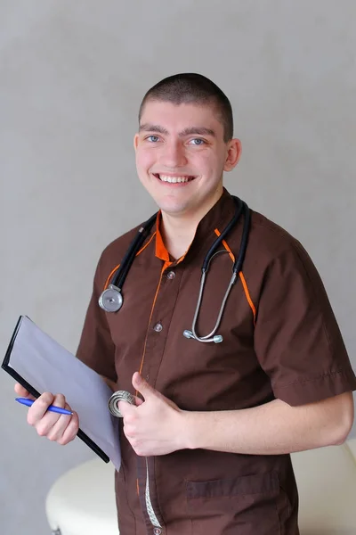 Professional male therapist looks at camera with smile and stand