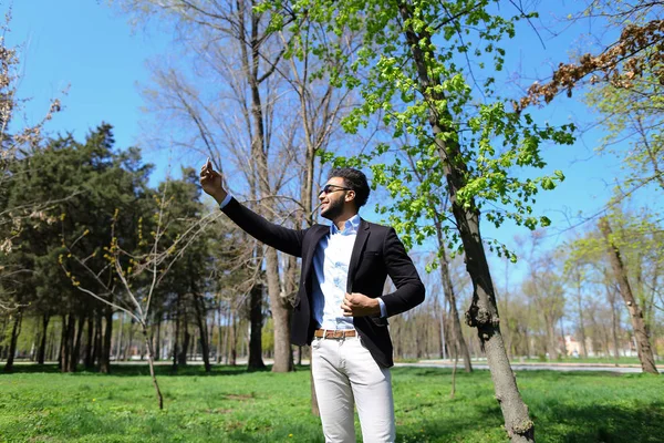 Muchacho musulmán probando nuevo teléfono y mostrando señal de paz de la mano en cámara lenta — Foto de Stock