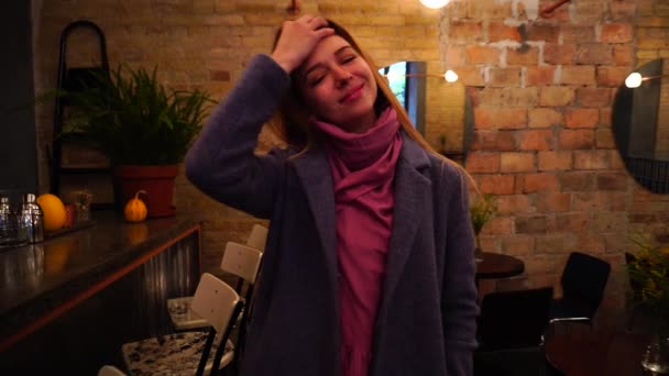 Дівчина ходить і посміхається в кафе вночі — стокове відео