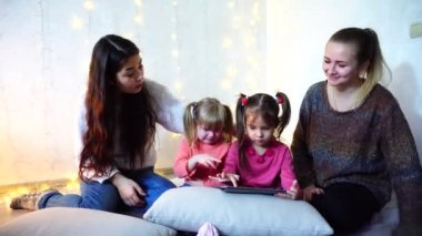 Yaşlı kadın ve bebek kız dört iletişim kurmak ve kendi işleri ile meşgul arka plan duvar odadaki garland ile katta oturan.