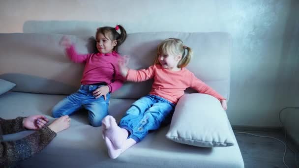 Moeder maakt opmerkingen aan kleine dochters, kinderen lachen in reactie. — Stockvideo