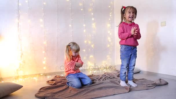 Niña divirtiéndose y bailando para la música, segunda chica se sienta enojada en el suelo . — Vídeos de Stock