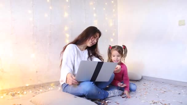 Young mother with little daughter sitting floor doing shopping at online store. — Stock Video
