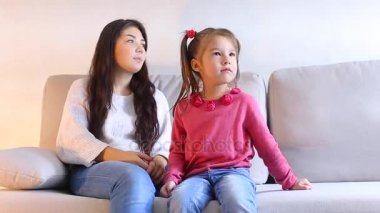 Anne ve küçük kızı kanepede oturan, çocuk bağırır, kadın kalkar ve goes uzağa.