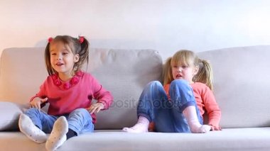 Kanepede, büyük oyun, küçük kız çocuk kırgın ve kızgın oturan iki kız kardeş.