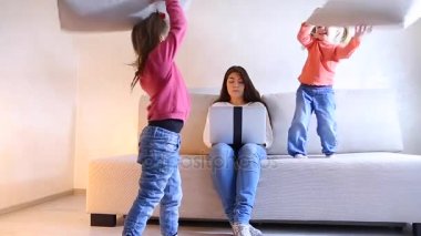 Genç anne laptop için Avrupa görünüm eserlerin iki küçük kızı kadın müdahale..