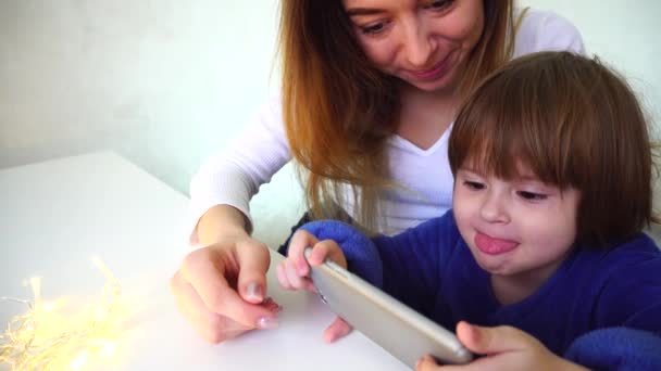 Tia mostrando fotos da viagem para a pequena sobrinha usando telefone inteligente . — Vídeo de Stock