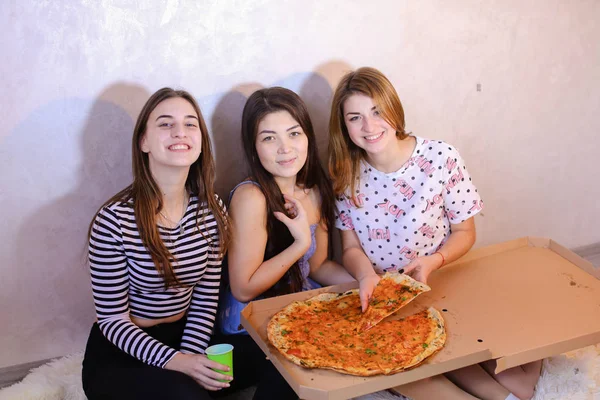 Meninas bonitos legal passar o tempo e desfrutar de pizza, sentar no chão em brigue — Fotografia de Stock