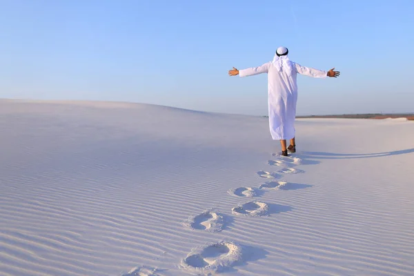 Joyful manliga muslimska promenader genom vita sandöknen och åtnjuter li — Stockfoto