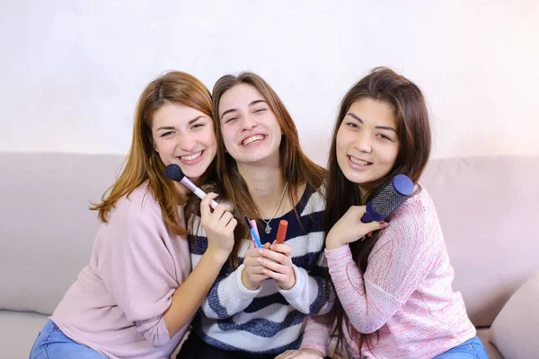 Drei attraktive junge Freundinnen posieren lächelnd vor der Kamera und — Stockfoto