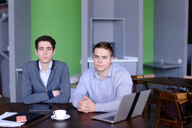 İki yakışıklı zeki işadamı veya tablo zekâ oturan çalışanlar