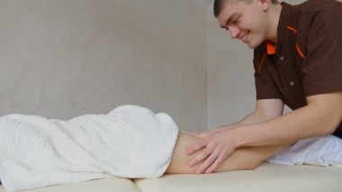Profesyonel masör bacaklar parlak Office kanepede yatan kız hasta kneads.