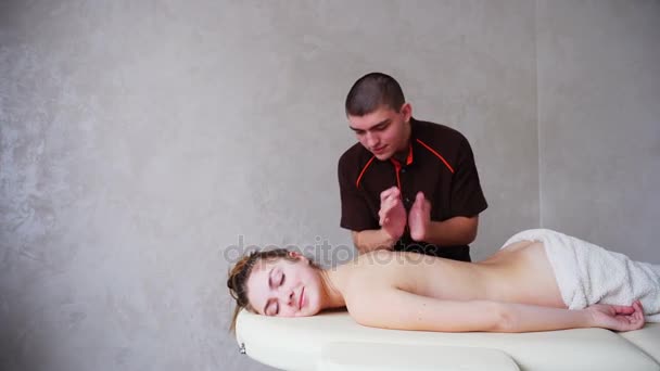 Professionele masseur kneedt meisjes terug naar de patiënt, die op de Bank in heldere kantoor ligt. — Stockvideo