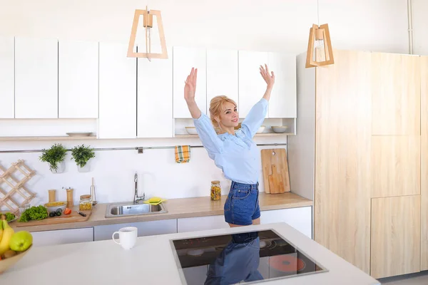 Pretty girl walks into kitchen and stretches, enjoying morning c