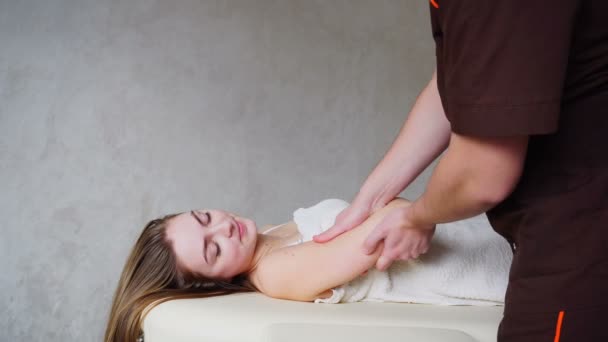 Médico especialista masculino com movimentos suaves faz massagem manual para o paciente no salão de sala médica . — Vídeo de Stock