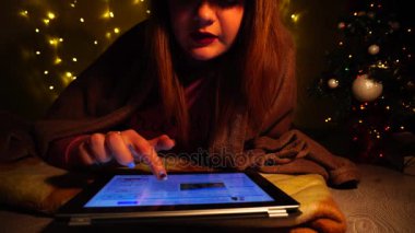 Genç öğrenci tarafından tablet neşeli hristmas şiir okuma.