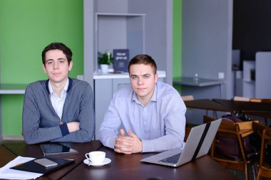 İki yakışıklı zeki işadamı veya tablo zekâ oturan çalışanlar