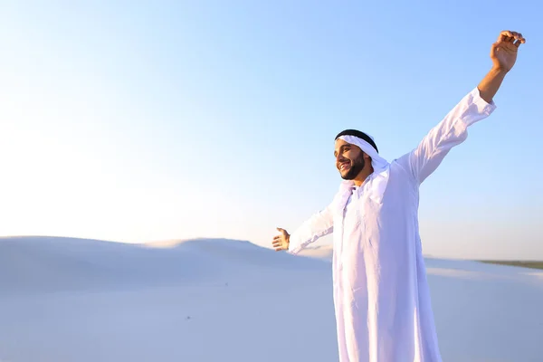 Glad muslimska killen går genom vidderna i öknen och vilar med — Stockfoto
