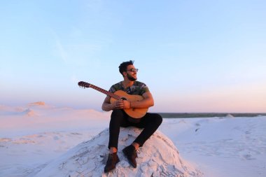 Çekici Arap adam gitar, Hill'de oturan şarkı söylüyor