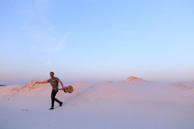 Arap adam çöl güzelliği ile ilham gider ve gitar çi çalış