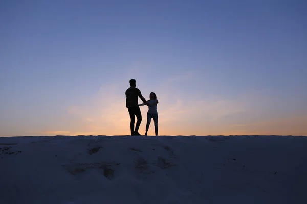 Aşıklar birbirlerine doğru koşmak ve çölde kum tepe üzerinde girdap — Stok fotoğraf