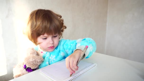 Liten amerikansk flicka med rosa penna lär sig att rita. — Stockvideo