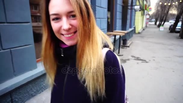 公正な髪の女の子が通りを歩いて、笑顔. — ストック動画