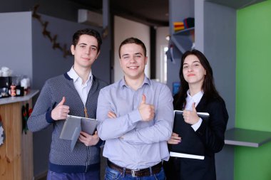 Üç kendine güvenen erkek ve kız öğrenci veya w ayağa çalışanlar