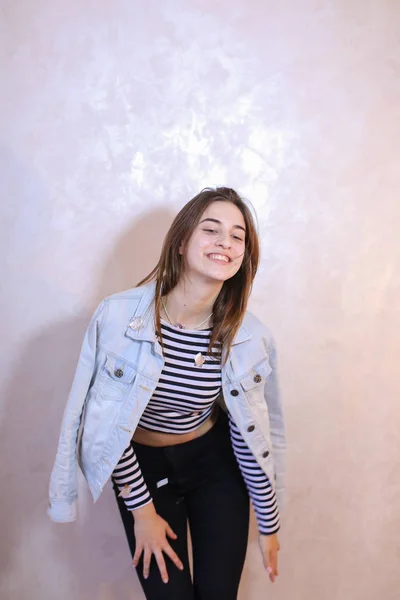 Mulher bonita com sorriso posando na câmera, de pé no fundo — Fotografia de Stock