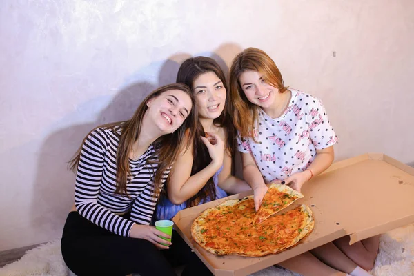 Chicas lindas fresco pasar tiempo y disfrutar de la pizza, sentarse en el suelo en bergantín — Foto de Stock